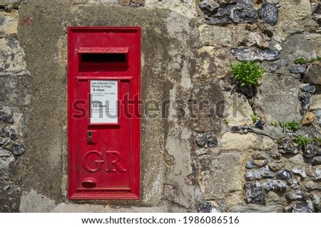 Red post box embedded in old city walls