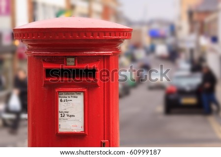 A red post box set against a de-focused city centre background