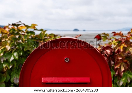 red postbox against the tidal flat seaside
