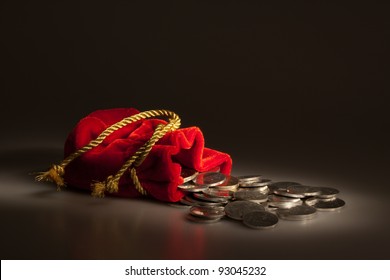 Red pouch with coins on the dark background