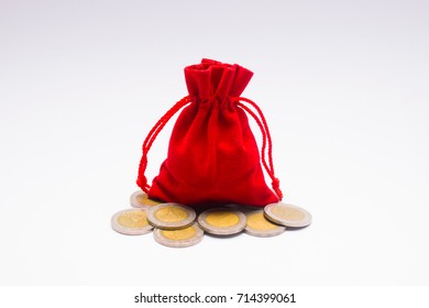 Red pouch and coins on white background.