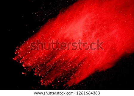 Red powder explosion isolated on black background.