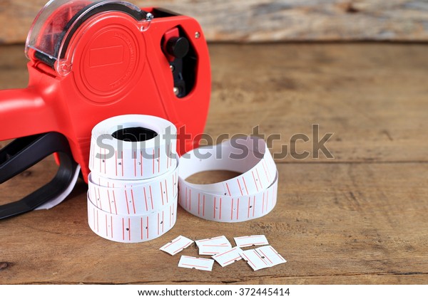 the red price label, price gun or price tag on\
wooden background
