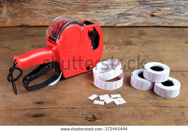 the red price label, price gun or price tag on\
wooden background