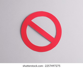Red prohibition sign cut out of paper on a gray background
