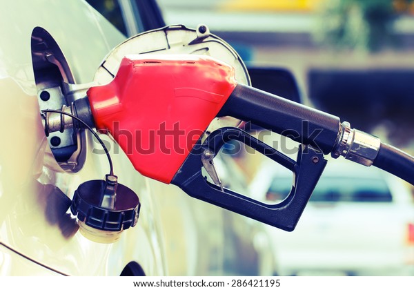 Red pumping\
fuel oil in car at gas\
station-retro