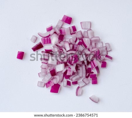 Red or purple onion chopped into small pieces in stack or pile is isolated on white background. Red onions cuts
