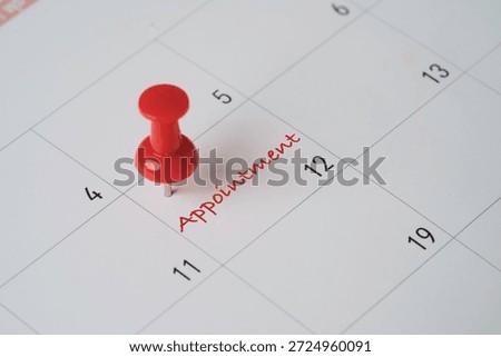 Red push pin marking an appointment date on a calendar symbolizing schedule planning,  reminder business deadline of time management  and important booking events organization concept.