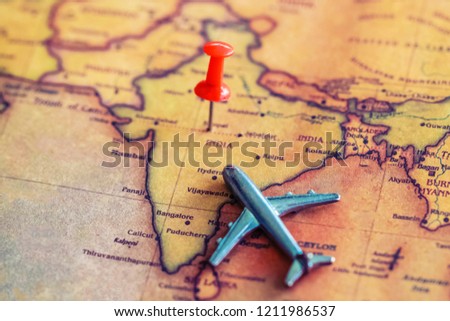 Red pushpin and mini airplane on India part of world map. Travel to India concept. Selective focus.