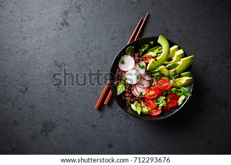 Red Quinoa Buddha Bowl with Avocado, Radish, Spring Onion, Cherry Tomatoes , Chive and Fresh Basil. Home made food. Concept for a tasty and healthy vegetarian meal. Top view. Copy space. 
