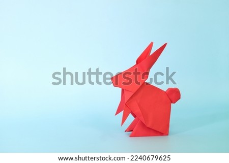 Red rabbit or bunny origami isolated in blue background. Chinese new year of the rabbit and easter celebration concept.