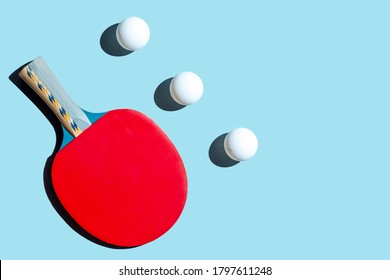 Red Racket For Table Tennis With White Balls On Blue Background. Ping Pong Sports Equipment In Minimal Style. Flat Lay, Top View, Copy Space.
