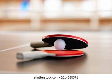 Red rackets and white ping-pong ball.