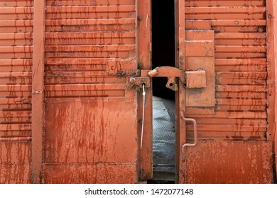 Red Railway Freight Car With An Open Door. The Lock On An Ajar Door With A Metal Seal.