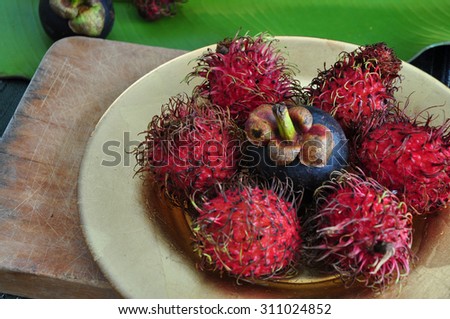 red rambutan and mangosteen asian fruits put on golden plate