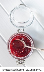 Red Rasberries Jam In Jar On White Table. Top View.