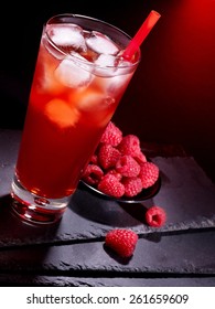 Red raspberry drink  with ice cube on black background. 
