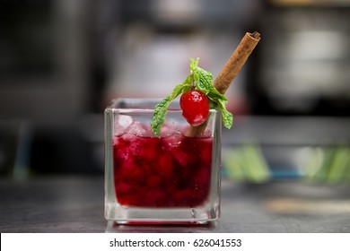 Red Raspberry Drink With Icecube Decoration With Cinnamon Stick,mint Leaves And Fresh Raspberry On The Tray And Empty Glasses