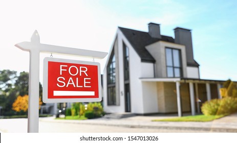 Red Real Estate Sign Near House Outdoors On Sunny Day