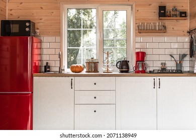 Red Refrigerator. White Kitchen Interior In A Country House. Black Microwave Oven. Black Teapot. French Windows. Kitchen Utensils.