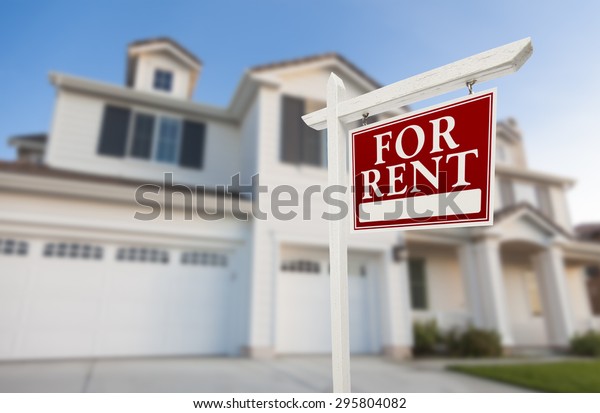 Red For Rent Real Estate Sign in Front of\
Beautiful House.