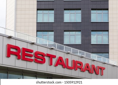 Red Restaurant Title On Modern Gray Tiled Building Facade.