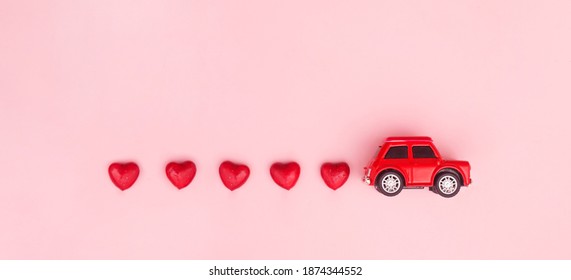 Red Retro Toy Red Car With Red Bow For Valentine's Day On Pink Background With Heart. Top View, Flat Lay, Banner