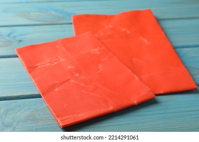 Red Reusable Beeswax Food Wraps On Light Blue Wooden Table, Closeup