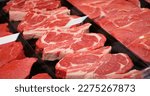 Red rib eye meat for sale in meat department in a shop. Raw fresh meat ribeye for steak perfectly arranged in trays.