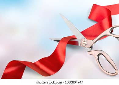 Red Ribbon With Iron Scissors On Blurred Background