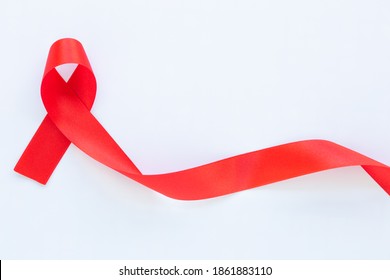 Red Ribbon On White Fabric Background With Copy Space, Symbol For The Solidarity Of People Living With HIV,AIDS, And For The Awareness And Prevention Of Drug Abuse And Drunk Driving. Health Concept.