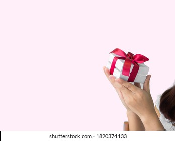 The red ribbon present or gift box in a small child's hands. Christmas or birthday present and thanksgiving, more give the more receive concept. people showing love in valentines day. - Shutterstock ID 1820374133
