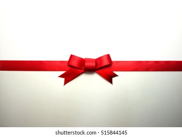 Red ribbon tie with very long ribbon extending on both sides. natural shadow on bottom half.