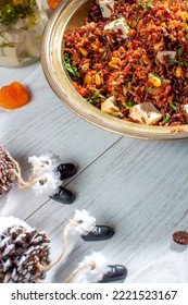 Red Rice Bowl With Christmas Decor And Aged Cutlery.