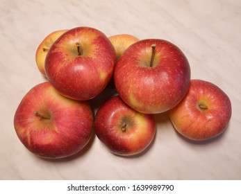 Red ripe apples on a white table.