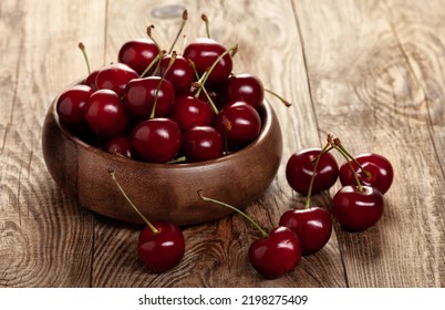 red ripe cherries in a wooden bowl on a building board. - Shutterstock ID 2198275409