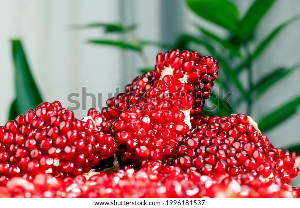 red and ripe fruit pomegranate with\
red grains, delicious and healthy pomegranate divided into several\
parts with red seeds, fresh pomegranate close\
up