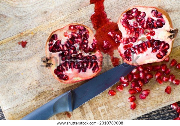 red and ripe fruit pomegranate with\
red grains, delicious and healthy pomegranate divided into several\
parts with red seeds, fresh pomegranate\
closeup