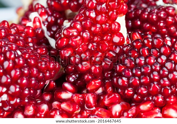 red and ripe fruit pomegranate with\
red grains, delicious and healthy pomegranate divided into several\
parts with red seeds, fresh pomegranate\
closeup