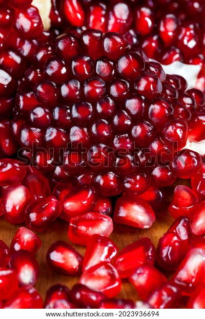 red and ripe fruit pomegranate with
red grains, delicious and healthy pomegranate divided into several
parts with red seeds, fresh pomegranate close
up