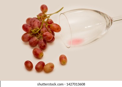 Red Ripe Grapes And Almost Empty Wine Glass