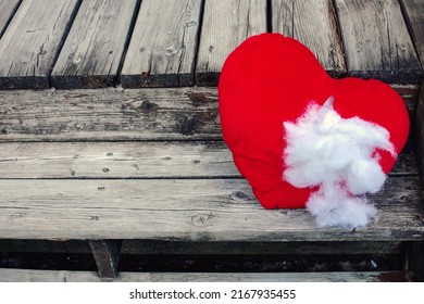 red ripped stuffed heart lying on old wooden steps