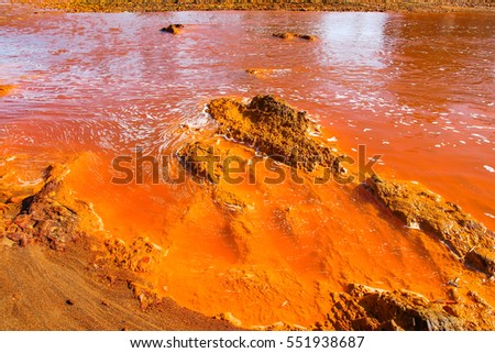Red river with red - yellow - orange acid stones. Red tinted river by copper on the ground. Water used in life study for life detection in Mars