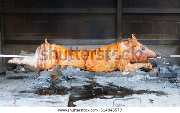 Red roasted juicy\
pig spinning on the spit