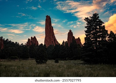 The red rock formations of Garden of the Gods rise against a clear blue sky, scattered with fluffy white clouds. The rugged landscape stretches beneath the bright, expansive sky - Powered by Shutterstock