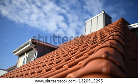 red roof house with red tiles an zinc chimney
