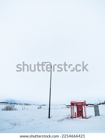 Red roofed electric car charger completely surrounded by snow at a service station in Iceland