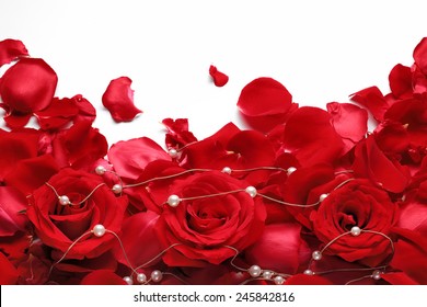 Red rose and beads on white background