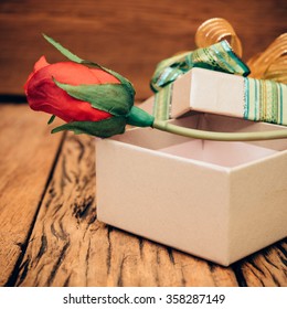 Red rose in gift box on old wood background. - Shutterstock ID 358287149