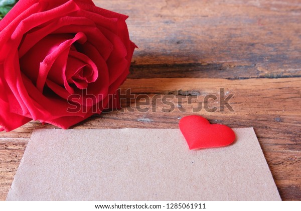 Red rose and mini heart with brown\
paper card. Copy space for Valentine\'s\
concept.